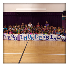Students and teachers pose with a YESO Thunderbirds sign