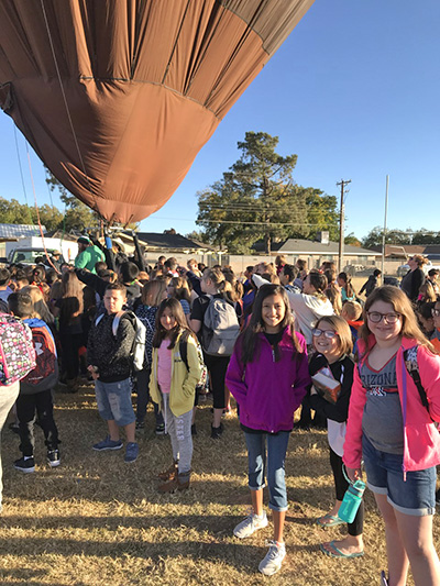 Students stand in front of a hot air balloon